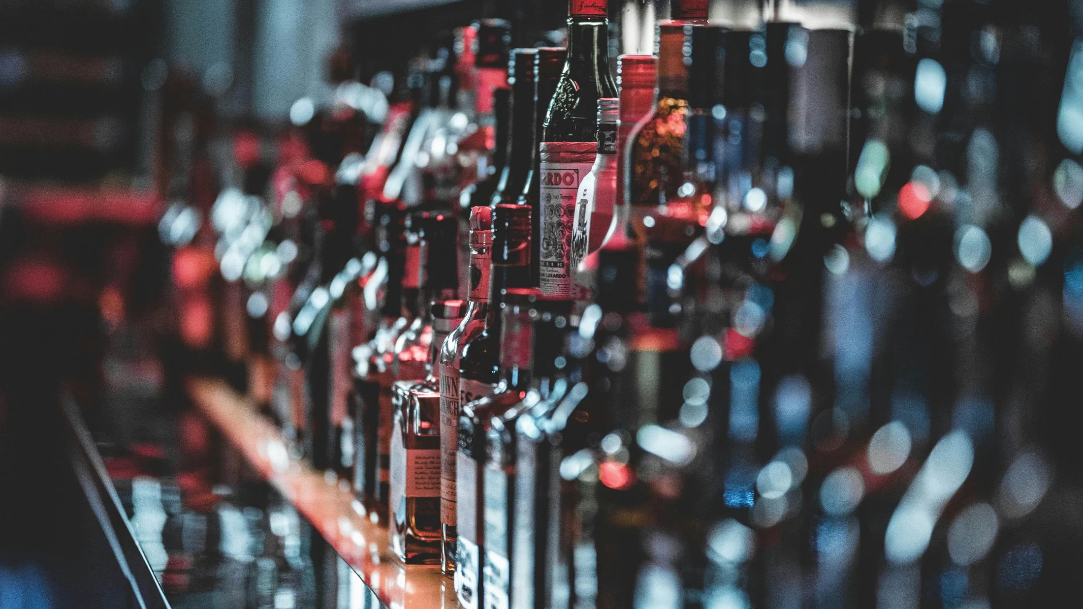 Backlit shelf of vodka and premium spirits bottles at ABLO Liquor in Calgary